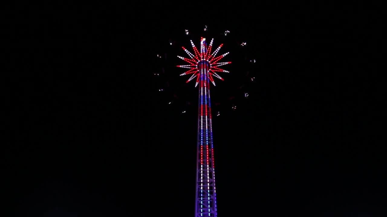 Starflyer In Orlando, Florida, USA - Amazing Tower With Colorful Dancing Lights And Spinning Rides Against A Night Sky - Low-Angle Shot