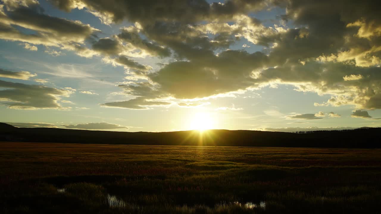 Time lapse of the clouds moving and sun setting over a field in Montana