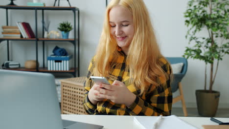 teenager using smartphone while studying at home