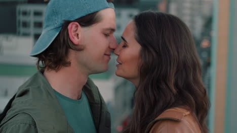 beautiful caucasian couple kissing on rooftop summer romance sharing intimate connection hanging out on roof at sunet