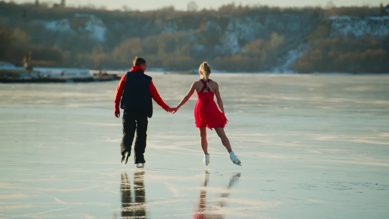 A Romantic Winter Ice Skating Scene on a Frozen Lake, Featuring a Couple Dancing Hand in Hand as They Glide Gracefully Across the Glassy Surface, Surrounded by Nature and Sparkling Waters Under Clear Skies