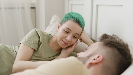 loving couple looking at each other while relaxing on the bed 1