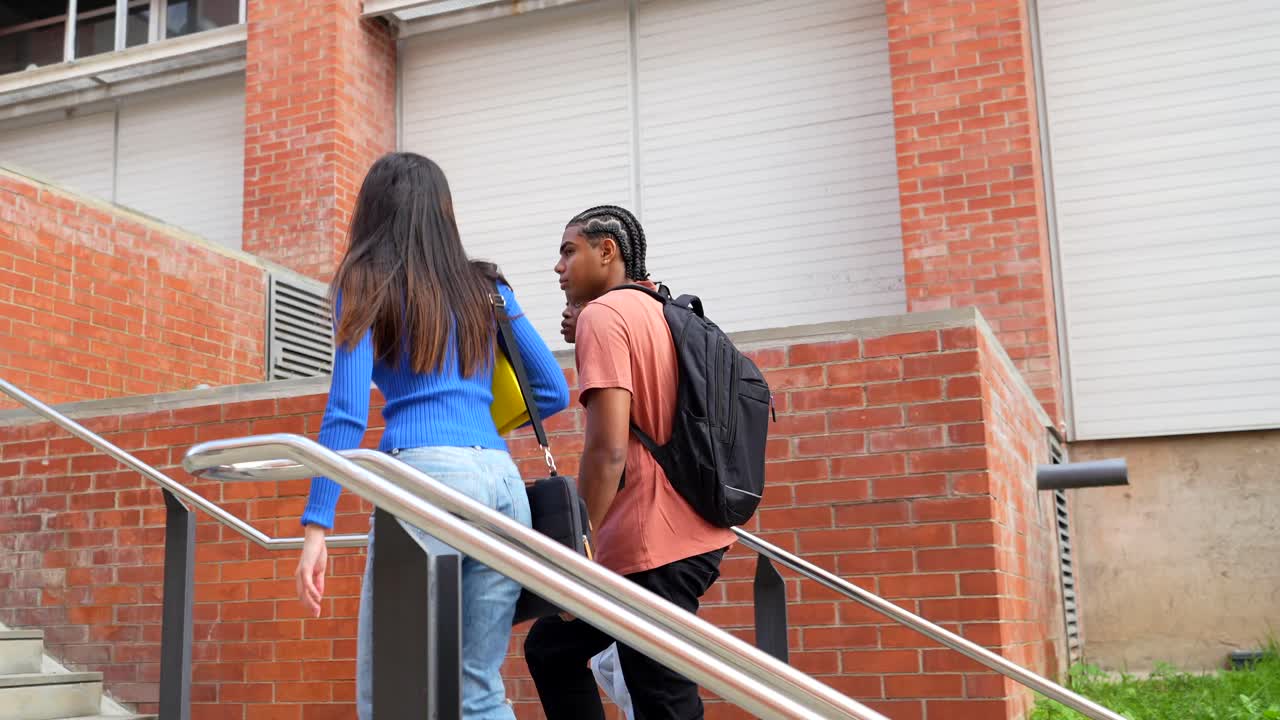 Studenti che salgono le scale vicino a un edificio in mattoni