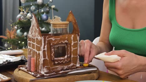 persona decorando una casa de pan de jengibre