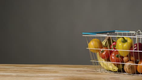 studio shot of basic fresh fruit and vegetable food items in supermarket wire shopping basket 2