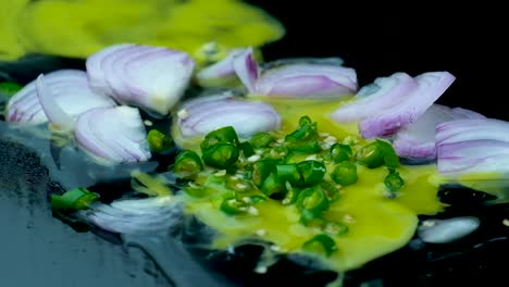 sliced green chili pepper falling on yellow egg yolk with onion