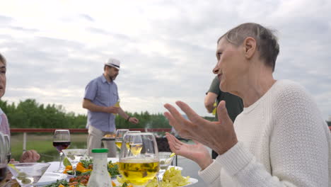 un grupo de personas mayores hablando y haciendo una barbacoa