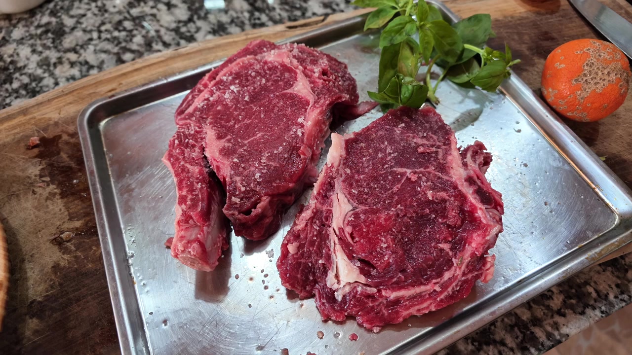Krydrede rå biffsteker hviler på et metallbrett, klare til å grilles for en tradisjonell argentinsk asado.