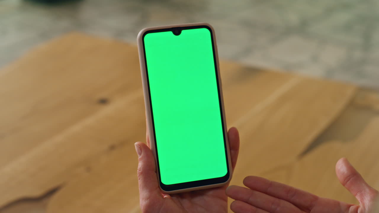 mujer gestualizada sosteniendo un teléfono de pantalla verde. director de primer plano mano gesticulando