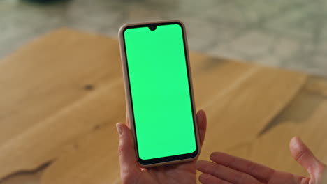 gesturing woman holding greenscreen phone. closeup director hand gesticulate