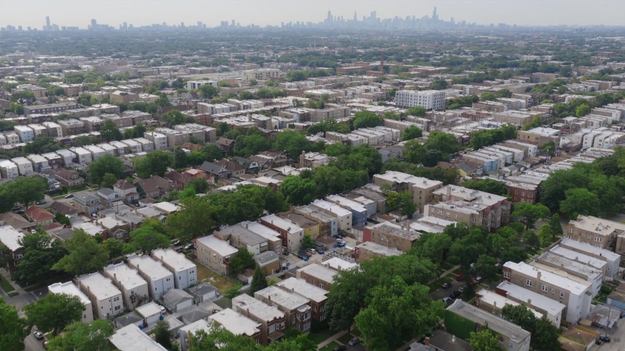Vista aerea di una fitta griglia residenziale di Chicago, con file di edifici plurifamiliari e tetti separati da strade alberate e vicoli