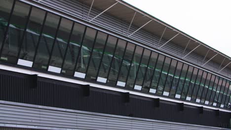 Cars-flying-past-in-reflection-of-windows-at-race-track