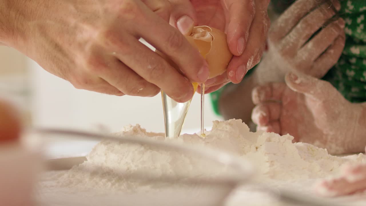 Handheld view of egg falling into flour