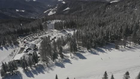 kope winter resort and car parking lot in the pohorje mountains in slovenia, aerial flyover shot