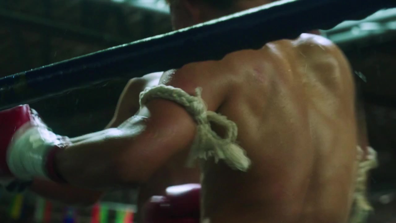 Riprese cinematografiche in slow motion 4K di due giovani combattenti thailandesi su un ring durante un incontro di Muay Thai in uno stadio a Chiang Mai, Thailandia