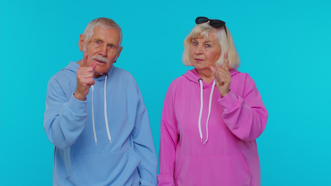 Senior grandfather grandmother shakes finger and saying no, be careful, giving advice avoid danger