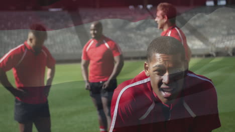 animation of flag of hungary over tired african american rugby player on pitch with teammates