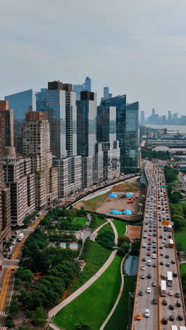 magnificent skyscrapers lined up over the river waterfront. lively highway with crazy traffic goes along the hudson river. top view.