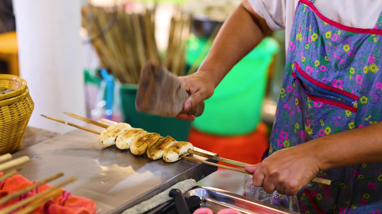 preparando plátanos a la parrilla en un puesto de comida callejera