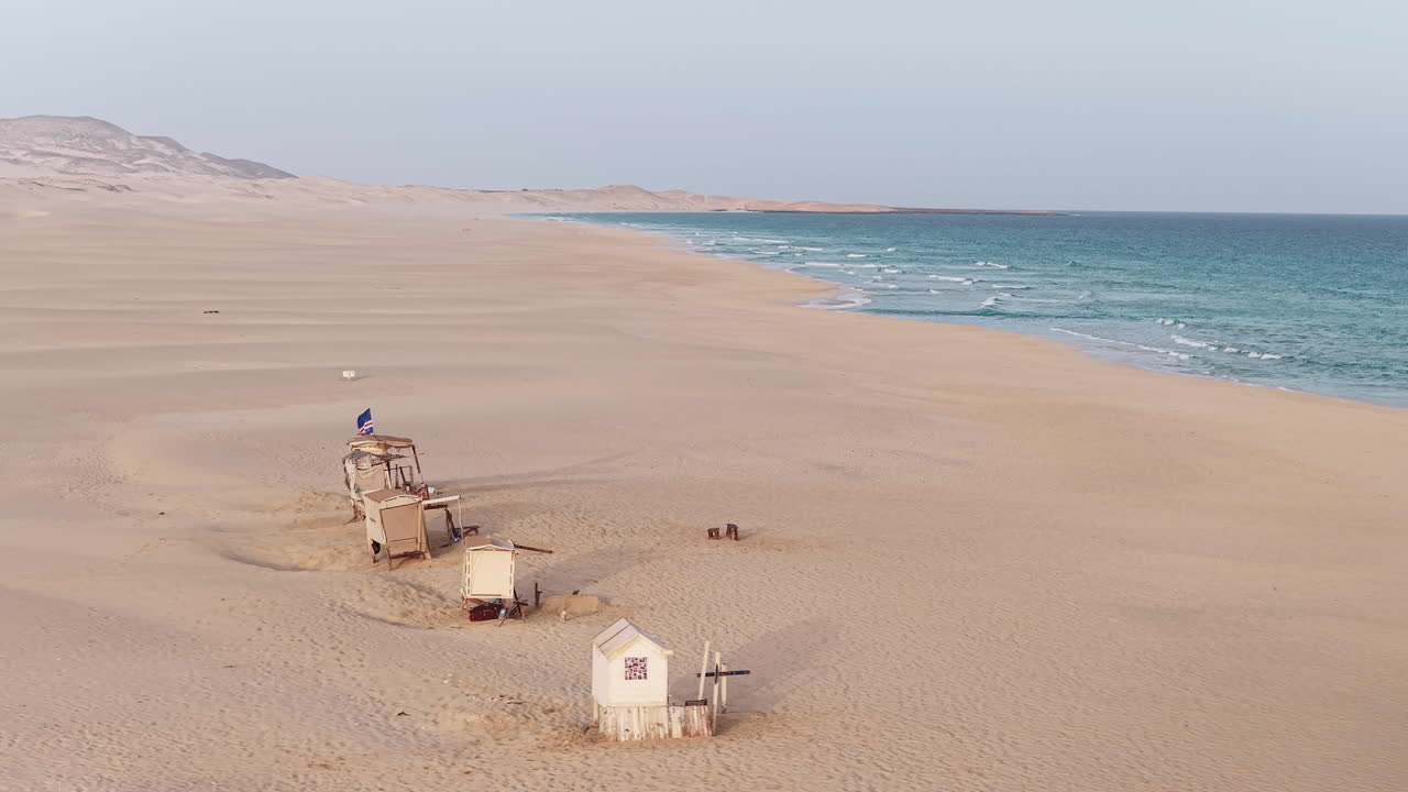 Praia de Chaves ( Chaves beach),Ocean,sandy dune and wooden shops on the beach with the Cape Verdean flag flying.Boa Vista island situated in the Atlantic Ocean.Cabo Verde, Africa