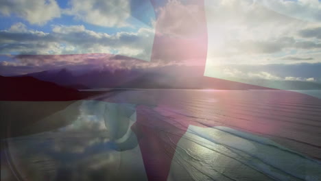 digital composition of england flag waving against aerial view of waves in the sea