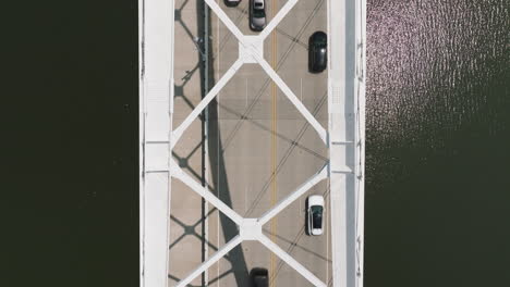 Top-down-view-of-vehicles-transiting-Broadway-Bridge-over-Arkansas-River,-Little-Rock,-Arkansas---Aerial-static-wide-shot