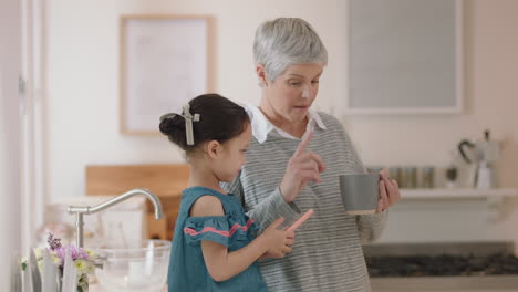 cute little girl showing grandmother how to use smartphone teaching granny modern technology intelligent child helping grandma with mobile phone at home