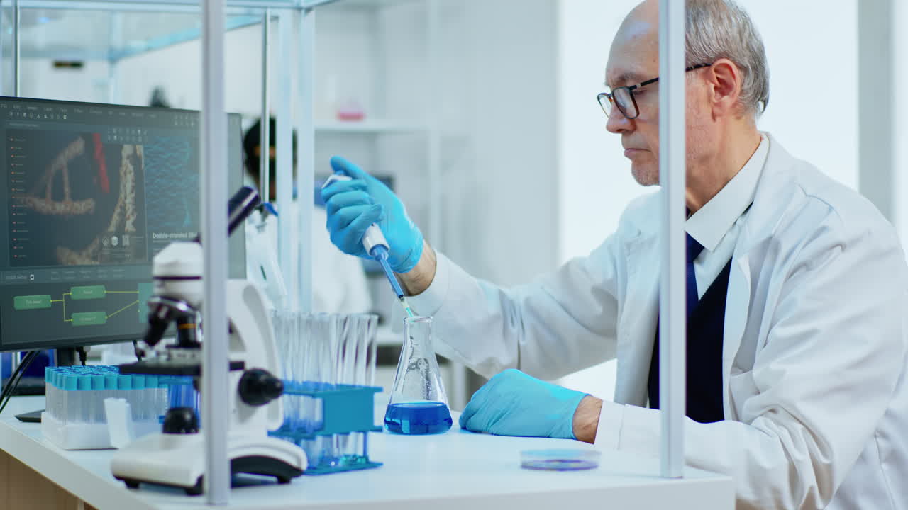 Elderly man scientist using micropipette for filling test tubes