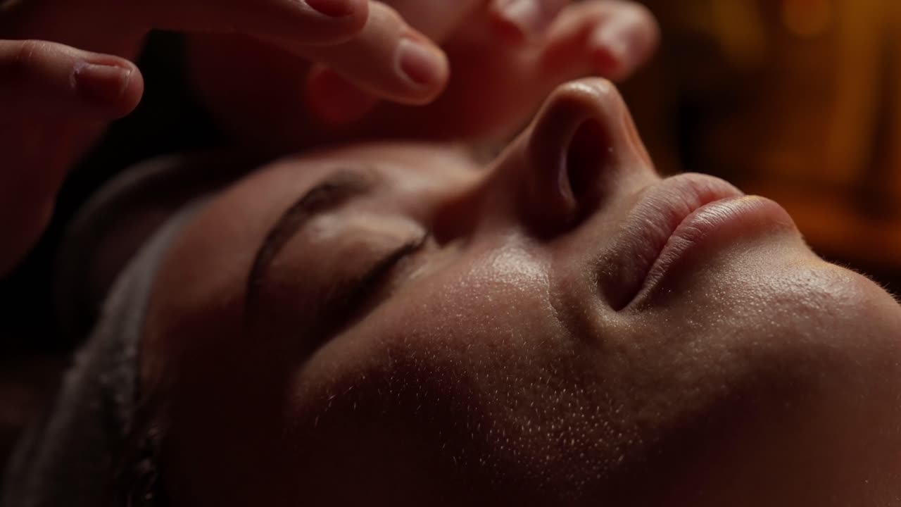 Nærbillede af kvinde, der får afslappende ansigtsmassage på et spa