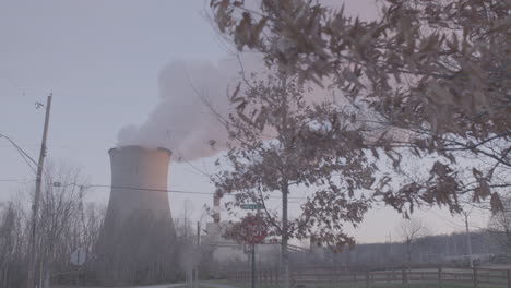 smoke stack, factory and fall trees in slo-mo