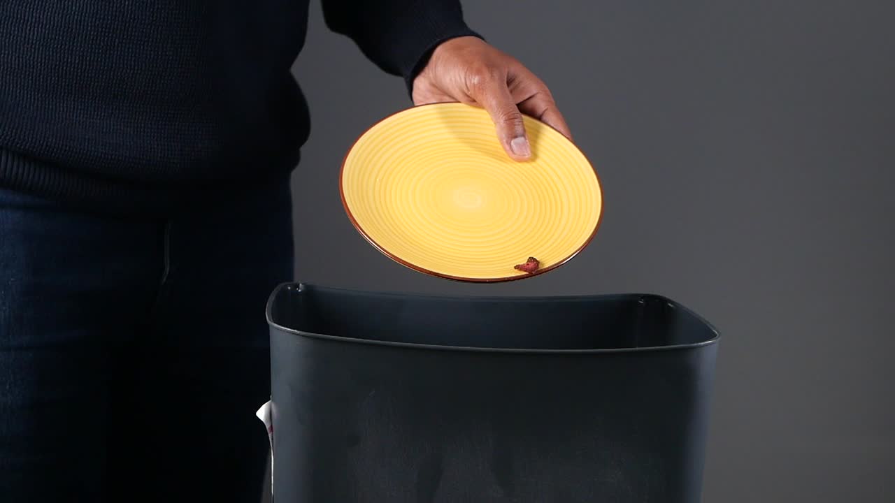 Persona che getta patatine fritte in un cestino