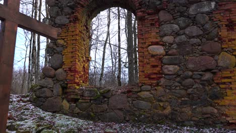 Wooden-church-cross-near-abandoned-boulder-wall-remains-with-arch-window