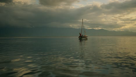 man sailing a traditional dug out canoe on a stormy afternoon