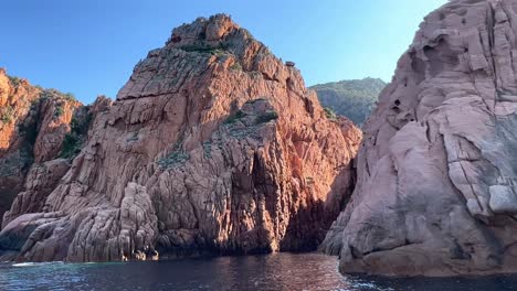 Magnificent-Calanques-de-Piana-volcanic-eroded-rock-formations-in-Corsica-island-as-seen-from-moving-boat-in-summer-season,-France