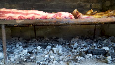 charcoiled beef meat roasting slowly in a traditional asado, argentina