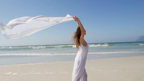 Frau-Steht-Mit-Einem-Wehenden-Schal-Am-Meer.-Am-Strand-4k