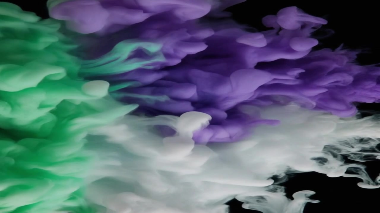 Nuvole di inchiostro verdi, viola e bianche che turbinano nell'acqua