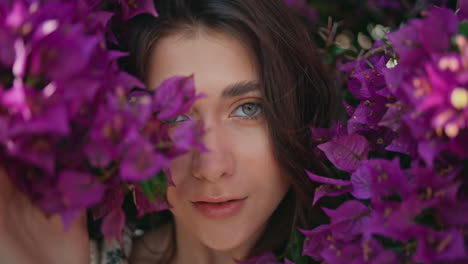 girl posing violet flowers bush background portrait. woman touching blossom