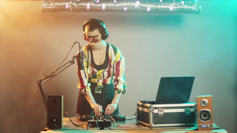 mujer dj envía besos al aire desde el escenario del club