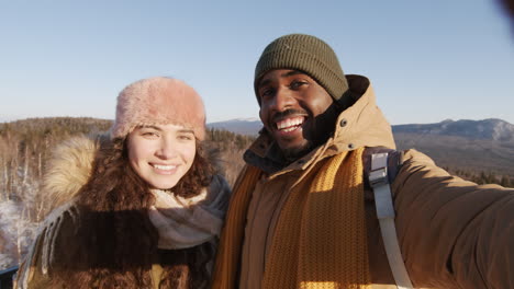 couple taking selfie on a mountaintop in winter