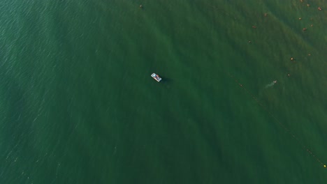 boat sailing on tranquil green ocean waters, captured from a high aerial view