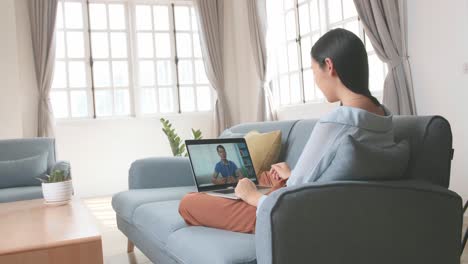 female use laptop computer and video call with friend in home living room, video in 4k