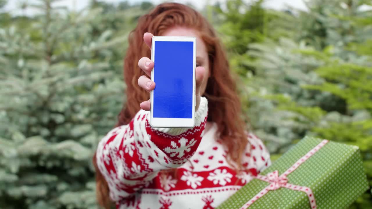 donna dai capelli rossi che mostra un telefono cellulare