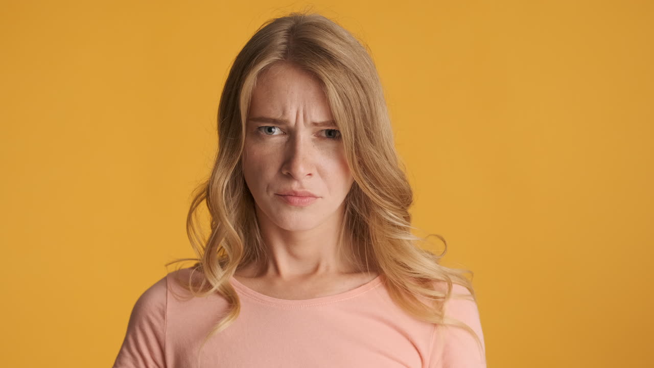 Caucasian woman looking upset on camera.