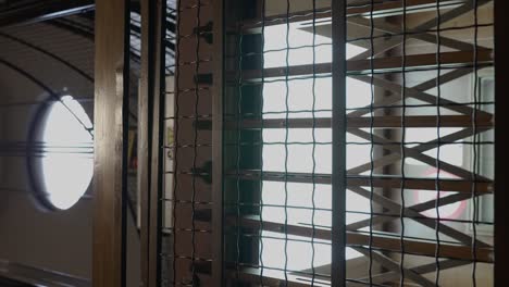 vertical video of empty old elevator descending and passing by at the floor of a building