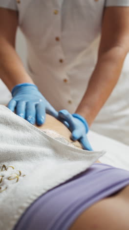 a masseuse giving a shoulder massage to a client in a spa - close up