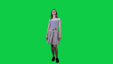 Teenage-girl-vibing-to-music-in-front-of-a-green-screen