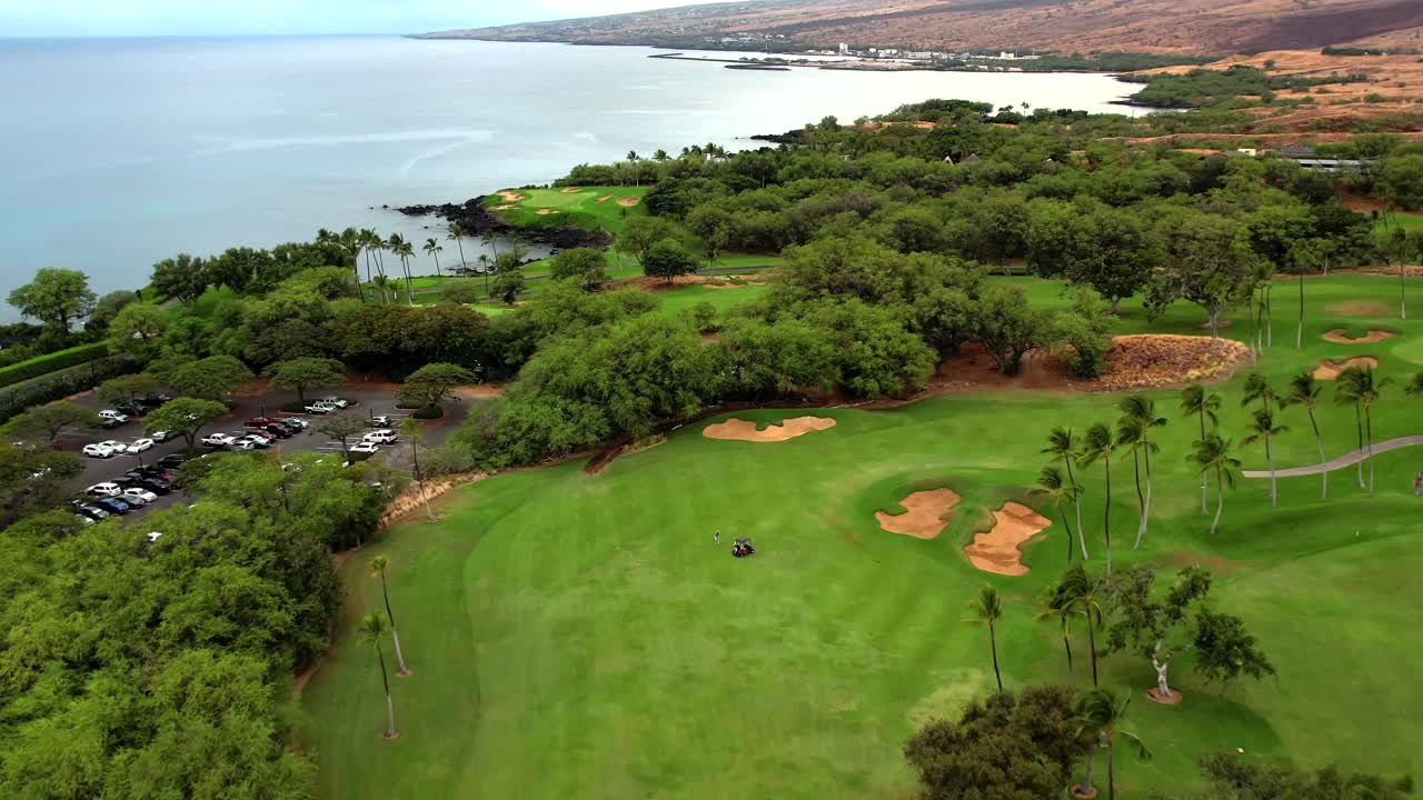 하와이의 바다 전망을 감상할 수 있는 해변 녹색 챔피언십 마누아 케아 골프 코스 위의 공중 드론