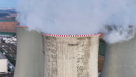 aerial ascend near nuclear power plant cooling towers emit water vapor