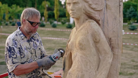 wood carver working on a mermaid sculpture